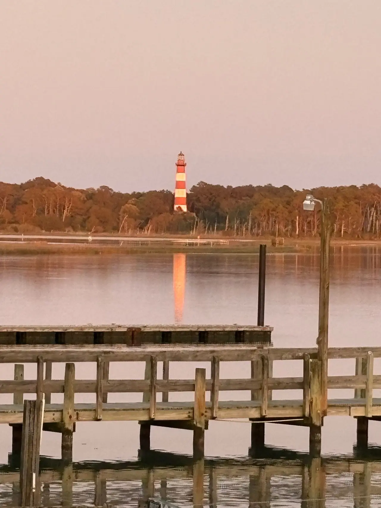 The Assateague Lighthouse at sunset across the water from the dock